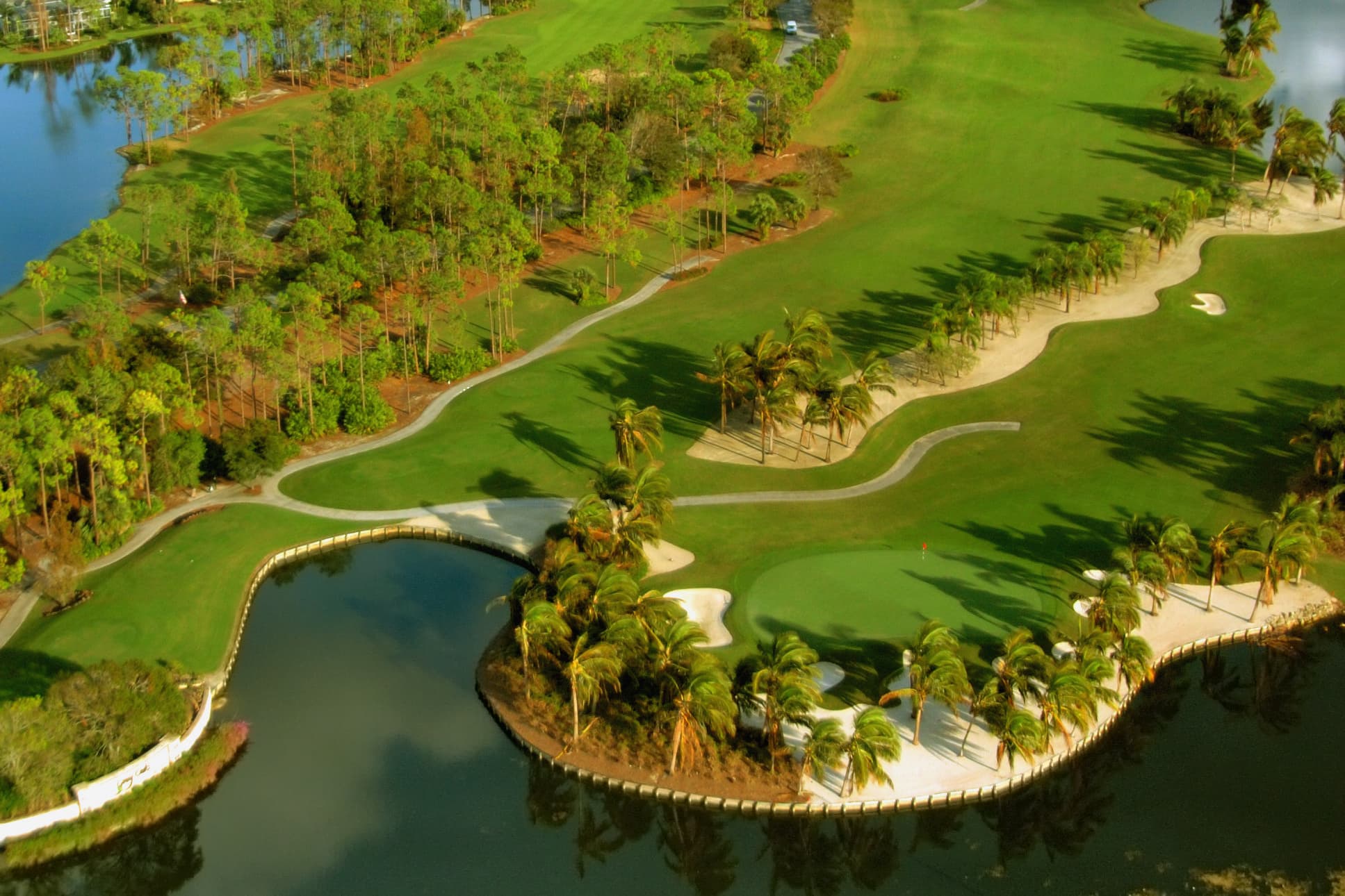 A Florida golf course green ringed by water and sand on the Gulf coast