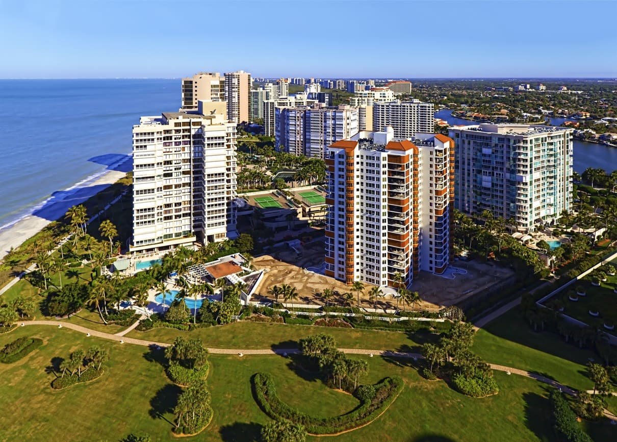Aerial view of beachfront high-rise condominium towers along the Gulf coast in Naples, Florida